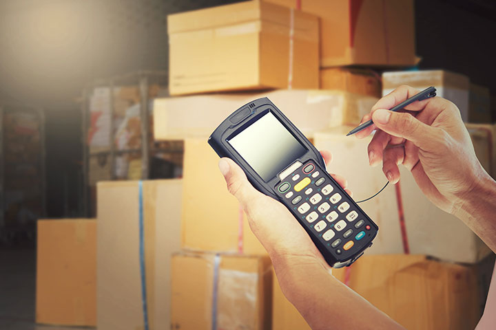 A person holding a payment machine to receive payment from the customer for the moving and packing services in Dubai.